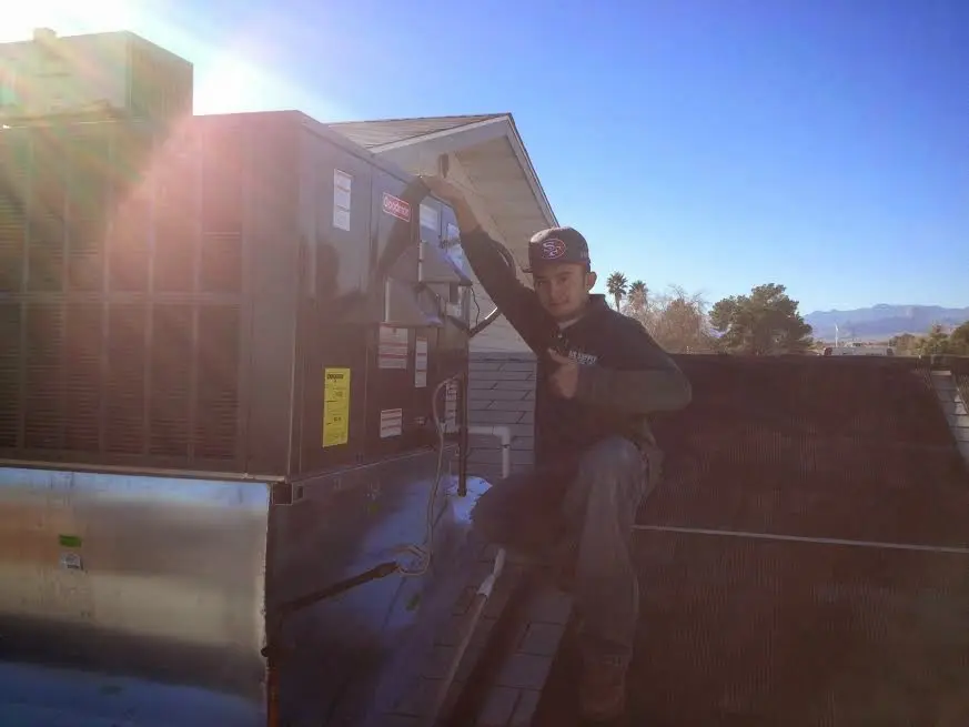 HVAC technician performing AC Tune-Up on a rooftop unit in Pleasanton